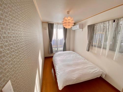 名古屋Villa Monica的一间小卧室,配有床和窗户