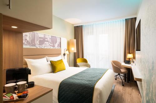汉堡Leonardo Hotel Hamburg Altona的配有一张床和一张书桌的酒店客房