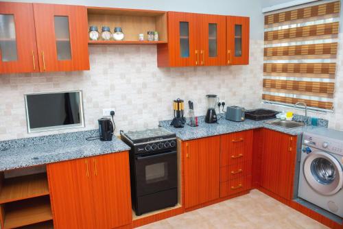 阿克拉William Ofori-Atta Fie的厨房配有木制橱柜和炉灶烤箱。