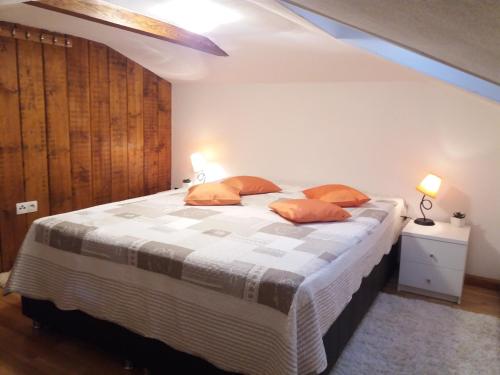 弗拉西克Apartmani Šišava Apt. Nancy的一间卧室配有一张带橙色枕头的大床