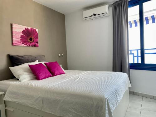 塔乌里托Apartment mit Traumblick的卧室配有一张带粉红色枕头的大床