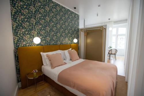 吉马良斯Trovador Guest House的一间卧室设有一张大床和绿色的墙壁