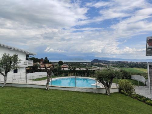 波尔佩纳泽德尔加尔达Bilocale in residence vista lago con piscina的享有带游泳池的庭院景致
