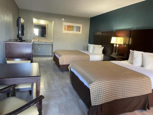 湖城Guest Inn Lake City的酒店客房配有两张床和一张书桌