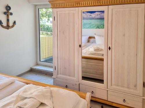 萨斯尼茨Ferienwohnung Sonnenblick的卧室设有大型白色橱柜和窗户