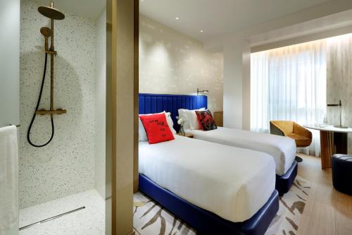 马德里Hard Rock Hotel Madrid的酒店客房带两张床和一间浴室