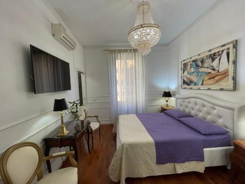 罗马国王广场住宿加早餐旅馆的一间卧室配有紫色的床和吊灯。