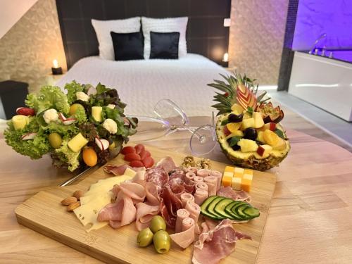 Champagne-sur-OiseL'Intemporel Suite Spa的一张桌子,上面放着食物,放在酒店的房间