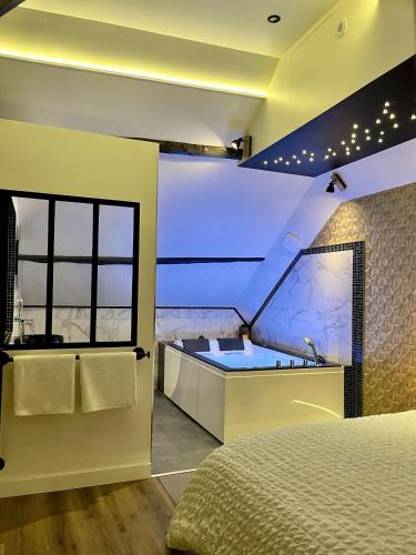 Champagne-sur-OiseL'Intemporel Suite Spa的一间带浴缸、床和水槽的卧室