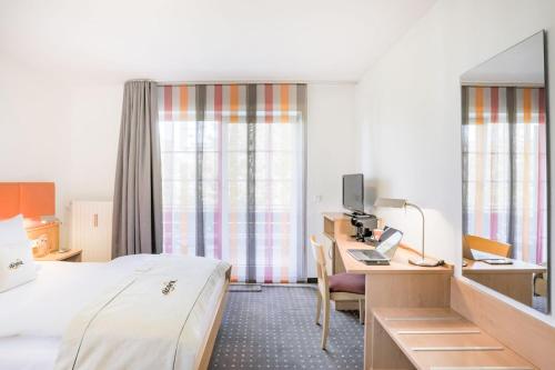 杜塞尔多夫acora Düsseldorf Living the City - Apartments的酒店客房配有一张床和一张带电脑的书桌