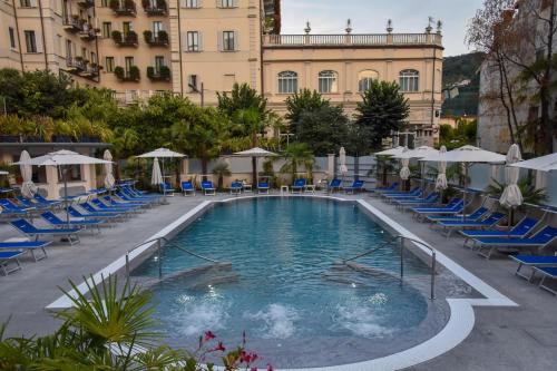 斯特雷萨阿索托丽亚酒店的游泳池,带椅子和遮阳伞