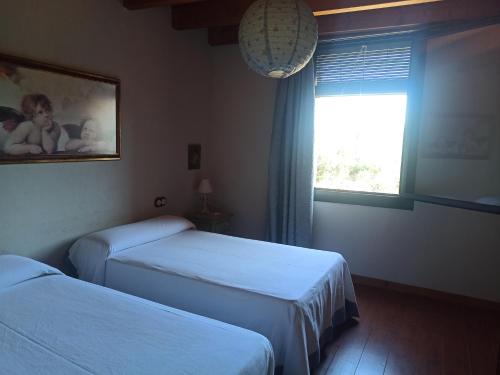 AvellanesEl Molí de Cal Pastisser的酒店客房设有两张床和窗户。