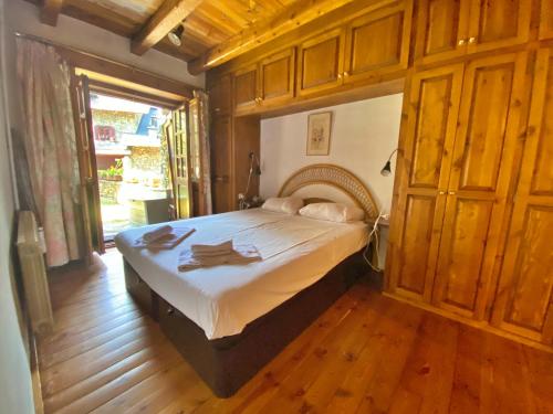奥尔迪诺Pleta de Ordino 55 Casa Rústica hasta 6 personas的铺有木地板的客房内设有一间卧室和一张床。