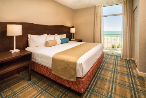 默特尔比奇Club Wyndham Ocean Boulevard的酒店客房设有一张床和一个大窗户