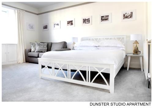 邓斯特Dunster Studio Apartment的卧室配有白色的床和沙发
