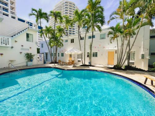 劳德代尔堡North Beach Hotel的棕榈树建筑前的大型游泳池