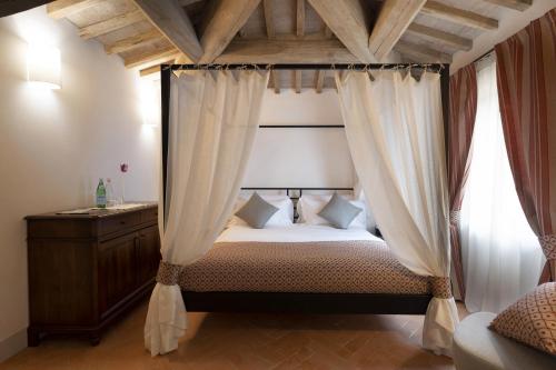 蒙塔尔奇诺Tenuta CastelGiocondo的一间卧室配有带窗帘的天蓬床