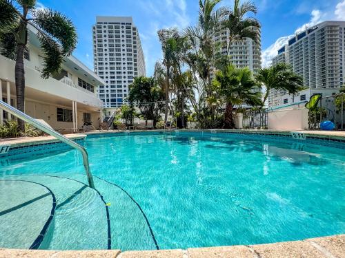 劳德代尔堡North Beach Hotel的一座棕榈树和建筑游泳池