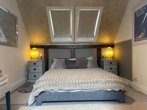 WinfortonStylish 2-bed cottage with secure parking的一间卧室配有一张带2个床头柜和2盏灯的床。