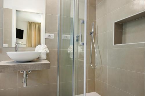 圣安蒂奥科Mercury Beach Hotel的一间带玻璃淋浴间和水槽的浴室