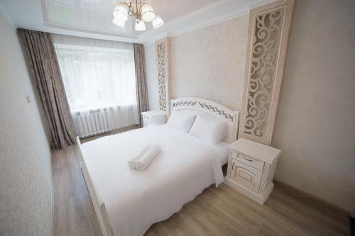 利沃夫Апартаменти з 2-ма ізольованими спальнями і балконом в центрі Львова的卧室配有白色的床和窗户。