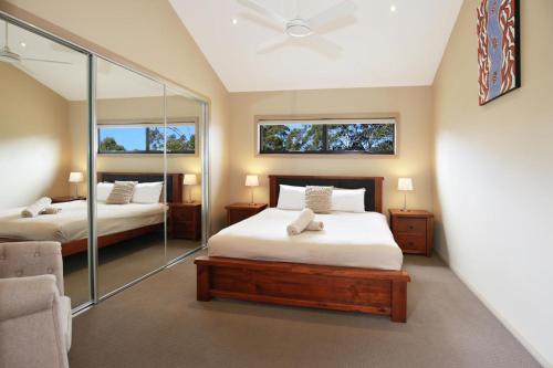 BewongPanorama at Jervis Bay I Pet Friendly I 15 Mins to Hyams Beach的一间卧室配有两张床和镜子