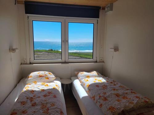 Brjánslækur红谷农家乐的两张床位于带窗户的房间内