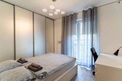 华沙FIRST -- Green Żoliborz Apartment 5的一间卧室设有一张床和一个窗口