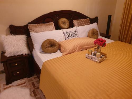 基苏木Jaja's One Bedroom near Ciala Resort Kisumu的床上有枕头,上面有鲜花托盘
