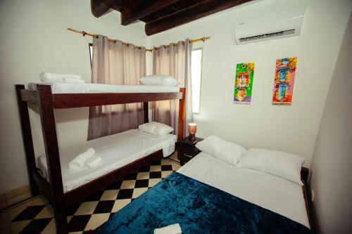卡塔赫纳Casa Hotel Marbella Beach的一间卧室设有两张双层床和一张可调节的地板。