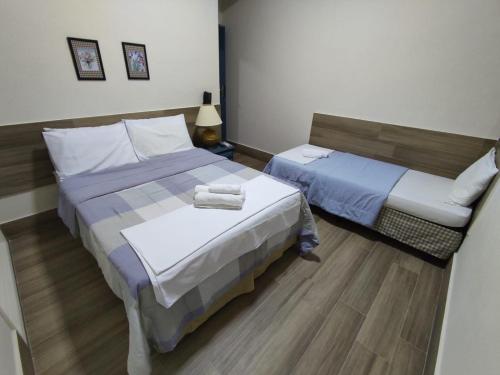 雷森迪AVENIDA HOTEL DE RESENDE的酒店客房设有两张床和一张桌子。