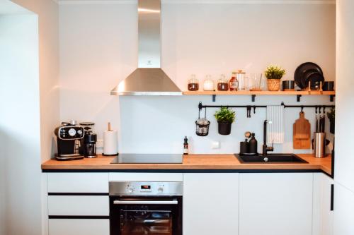 ĶesterciemsAlbatross Dimants - apartamenti Rīgas jūras līča krastā的厨房配有白色橱柜和炉灶。