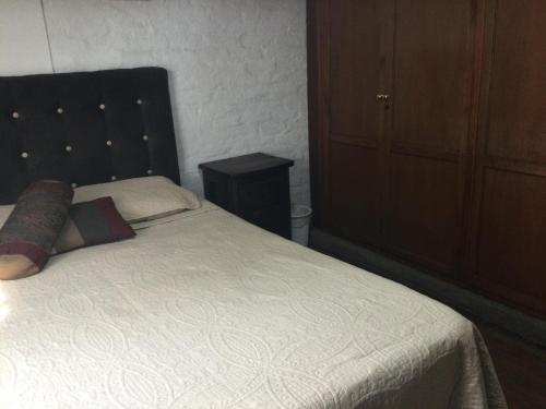卡利Beautiful Colonial House的一间卧室配有一张白色的床和黑色床头板
