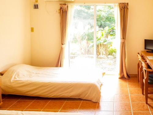 石垣岛AsobiBASE Yamabare-House的一间卧室设有一张床和一个大窗户