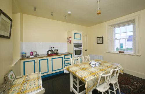 KilbahaLoop Head Lightkeeper's House的厨房配有桌子、水槽和桌椅