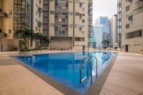 马尼拉2 BR loft-type condo Fort Victoria的大楼中央的大型游泳池