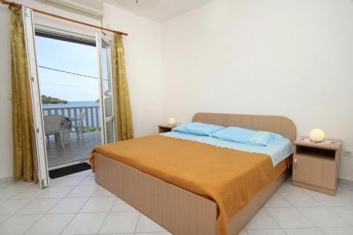 莫鲁纳特Apartments by the sea Molunat, Dubrovnik - 8956的一间卧室设有一张床和一个阳台