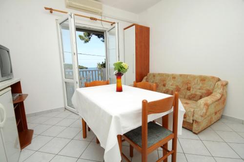 莫鲁纳特Apartments by the sea Molunat, Dubrovnik - 8956的客厅里设有一张桌子,上面有花瓶