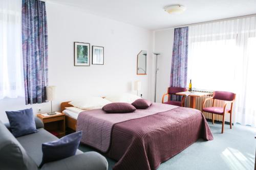 克拉尼斯卡戈拉维拉罗马纳旅馆的一间卧室配有一张带紫色毯子和椅子的床