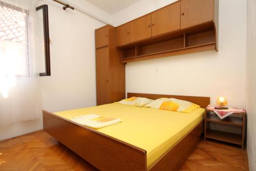 杜布罗夫尼克Apartments with a parking space Dubrovnik - 9099的一间小卧室,配有一张黄色床单