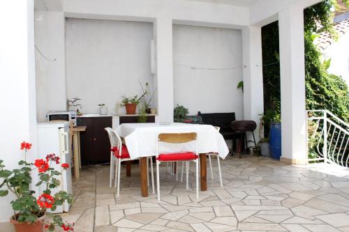 杜布罗夫尼克Apartments with a parking space Dubrovnik - 9099的庭院里的白色桌椅
