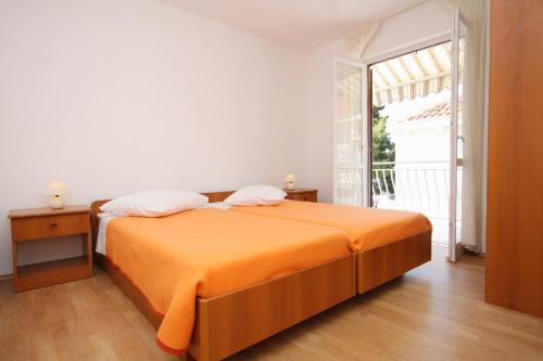 格鲁达Apartments and rooms by the sea Molunat, Dubrovnik - 9102的窗户客房内的橙色床
