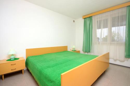 布拉托Apartment Prigradica 9141b的一间卧室设有一张绿色的床和一个窗户。