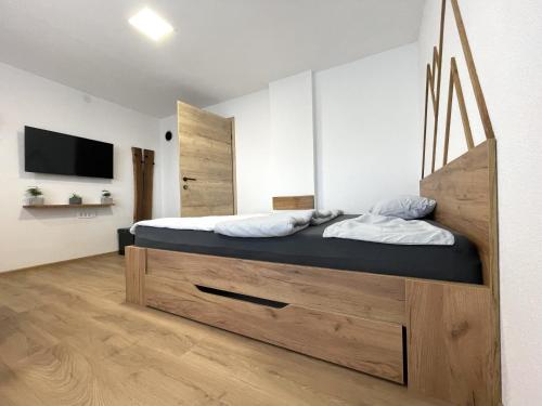采尔克诺Apartments and rooms pri Bašlju的一间卧室配有一张大床和木制床头板