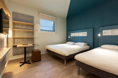 布尔昆Ibis Budget Bourgoin Jallieu Centre的小房间设有两张床和一张书桌