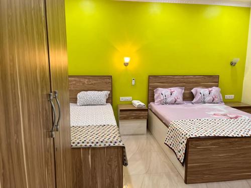 罗纳瓦拉Chandra Villa 12Bhk Lonavala的黄色墙壁的客房内的两张床