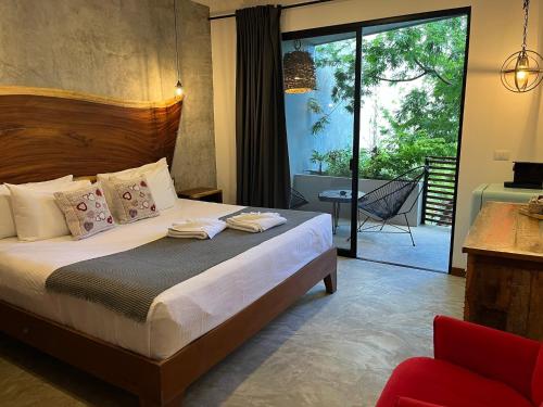 图卢姆Little Gem Hotel Tulum La Veleta的一间卧室设有一张床和一个滑动玻璃门