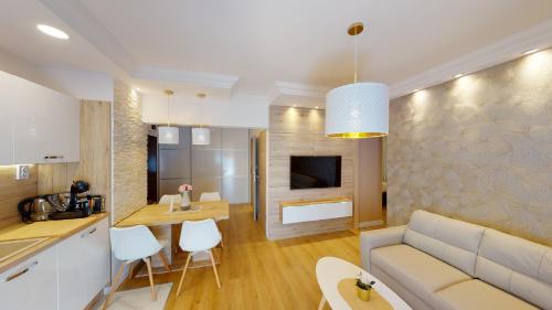萨格勒布Zagreb4you Apartments的厨房以及带沙发和桌子的客厅。