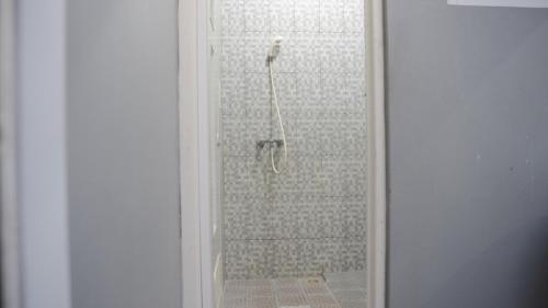 直葛Sitiinggil Guest House Syariah的带淋浴的浴室,带玻璃门
