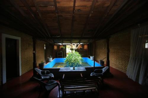 锡吉里亚Sigiri Peace Hostel的一间有桌子的房间,里面装有植物